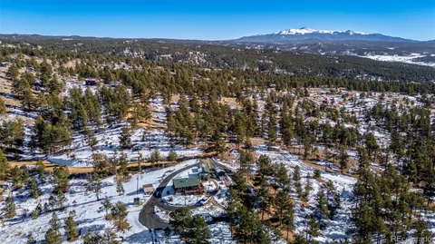 an aerial view of residential houses with outdoor space and trees