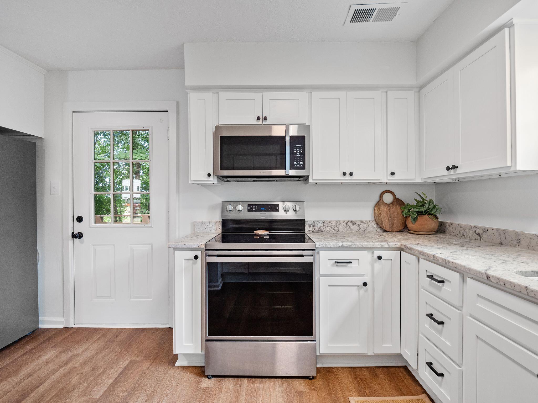 1701 Glendon Road Salem, VA 24153 - Photo 14 of 43 a kitchen with granite countertop a stove a microwave a sink and cabinets