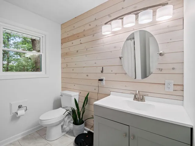 a bathroom with a sink a toilet and a mirror