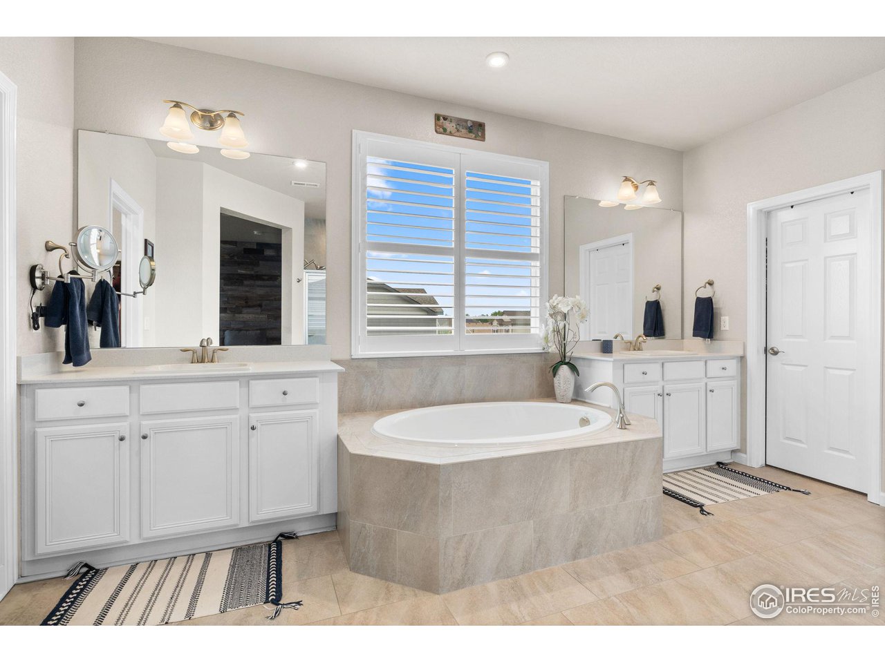 803 Old Wagon Trail Circle Lafayette, CO 80026 - Photo 14 of 30 a spacious bathroom with a tub double sink window and mirror