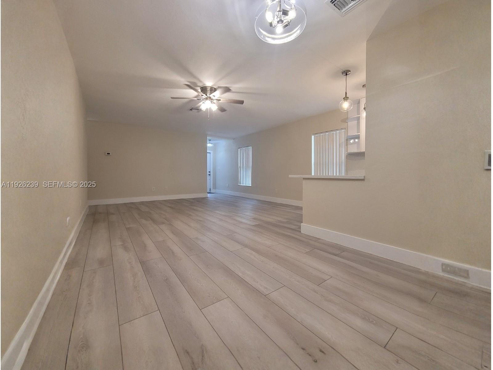 19066 Bob-O-Link Drive Hialeah, FL 33015 - Photo 3 of 11 wooden floor in an empty room with a window