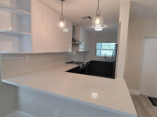 a kitchen with a refrigerator a stove a sink and a window