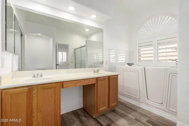 a spacious bathroom with a double vanity sink a mirror and a bathtub