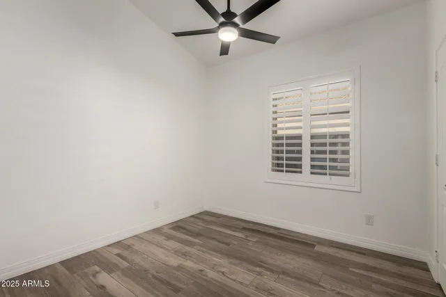 an empty room with a window and ceiling fan