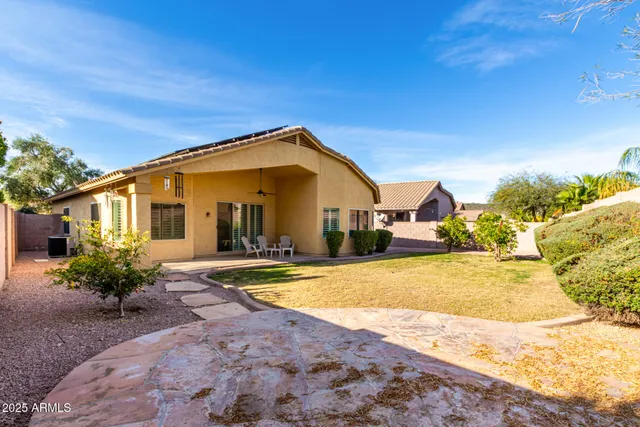 a front view of a house with a yard outdoor seating and covered with trees