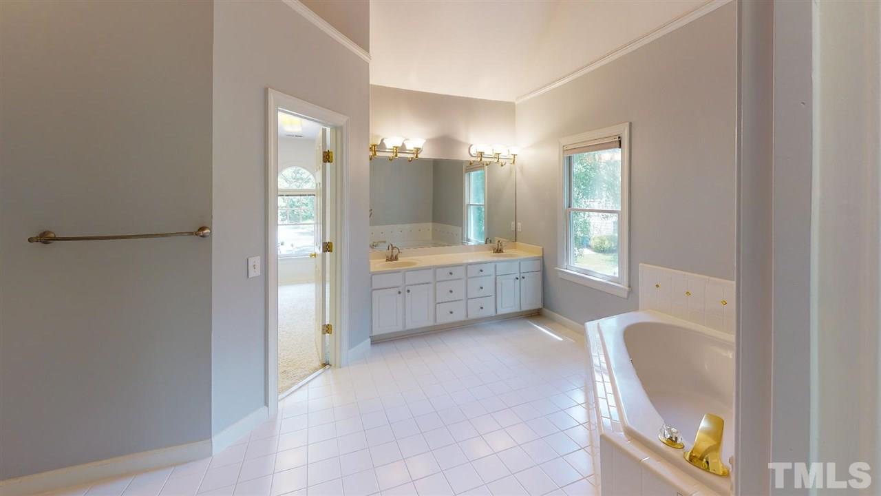 8212 Gaspari Court Raleigh, NC 27615 - Photo 13 of 18 a bathroom with a tub shower and mirror
