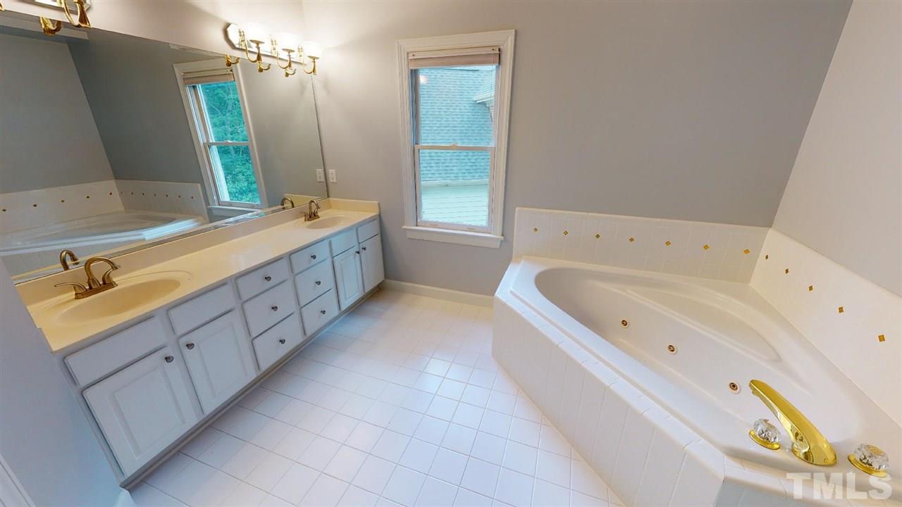 8212 Gaspari Court Raleigh, NC 27615 - Photo 14 of 18 a bathroom with a tub sink and mirror