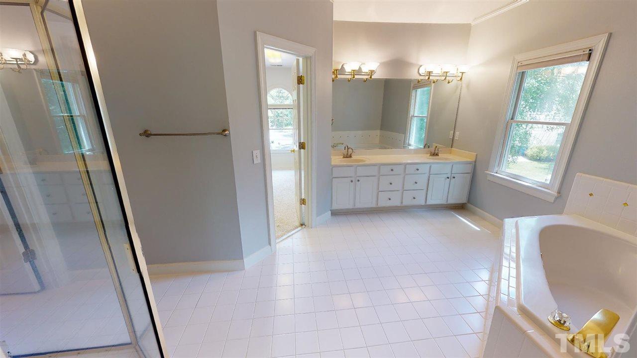 8212 Gaspari Court Raleigh, NC 27615 - Photo 15 of 18 a bathroom with a double vanity sink toilet mirror and window