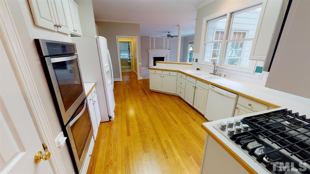 8212 Gaspari Court Raleigh, NC 27615 - Photo 4 of 18 a kitchen with stainless steel appliances a refrigerator a sink a stove and white cabinets