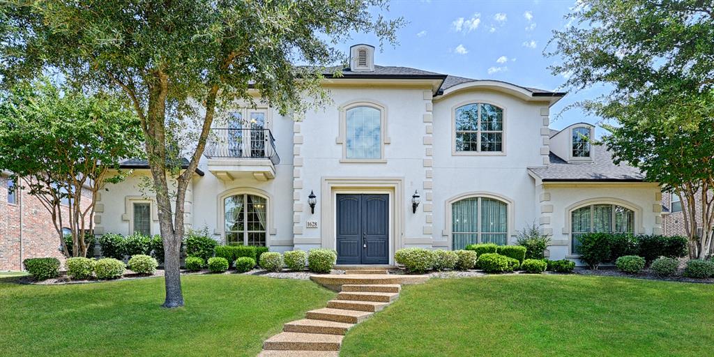 View of front of home featuring a balcony, a shingled roof, stucco siding, and a front lawn