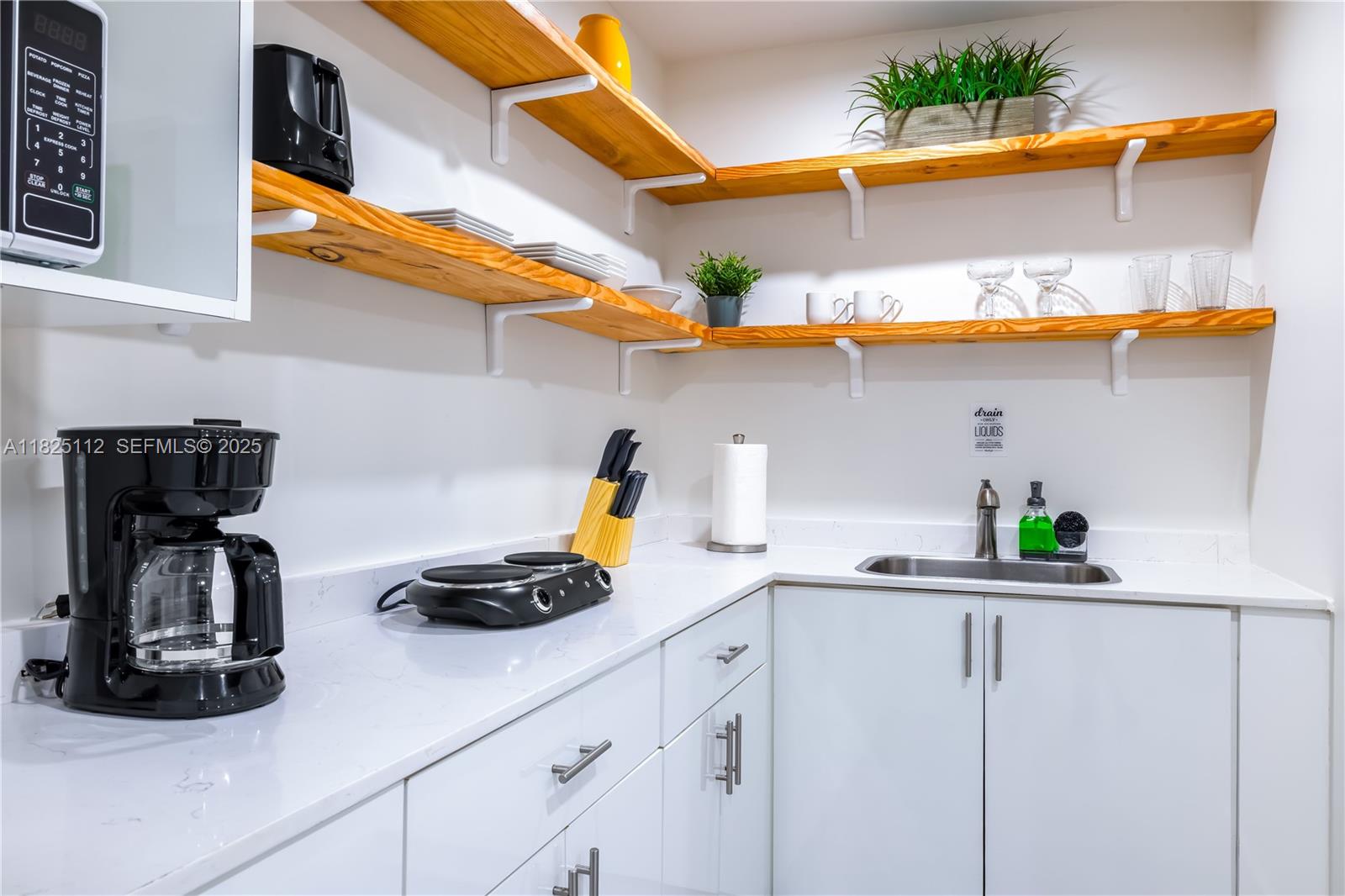1836 Northwest 16th Terrace, Unit 3 Miami, FL 33125 - Photo 2 of 15 a kitchen with stainless steel appliances granite countertop a sink a stove and a wooden cabinets