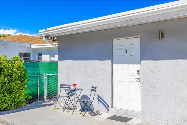 a view of a patio with a table and chairs and potted plants