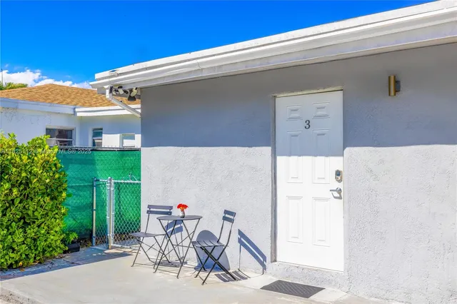 a view of a patio with a table and chairs and potted plants