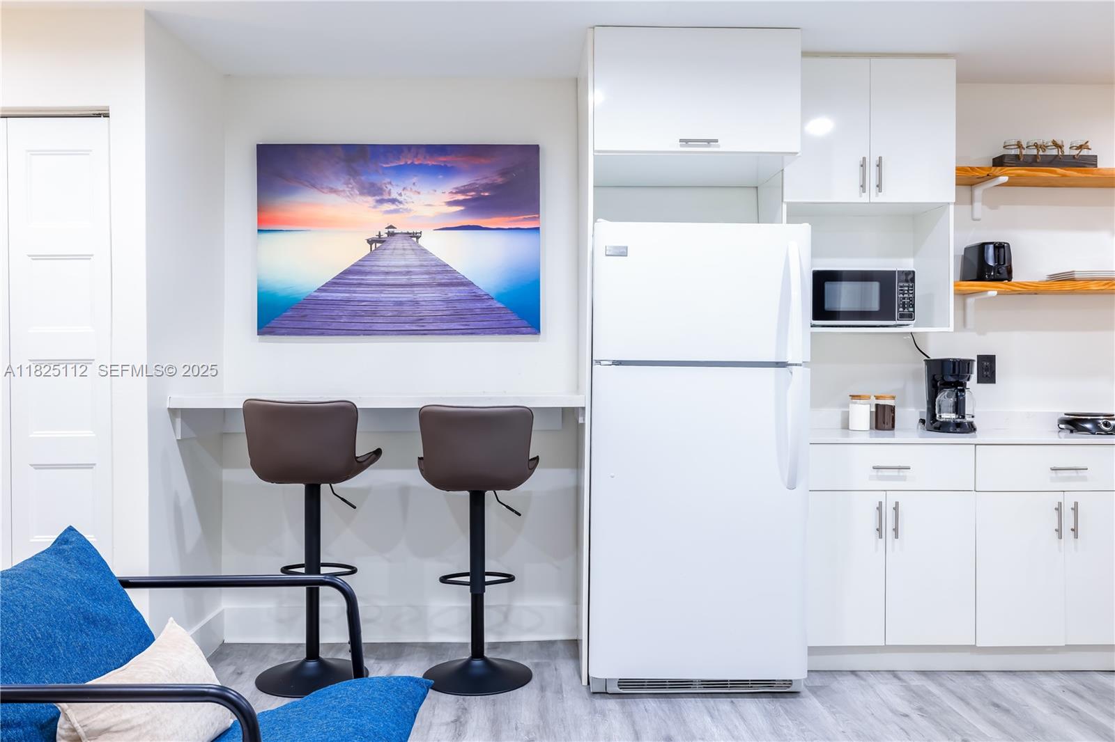 1836 Northwest 16th Terrace, Unit 3 Miami, FL 33125 - Photo 7 of 15 a kitchen with stainless steel appliances granite countertop a refrigerator a stove a dining table and chairs with wooden floor