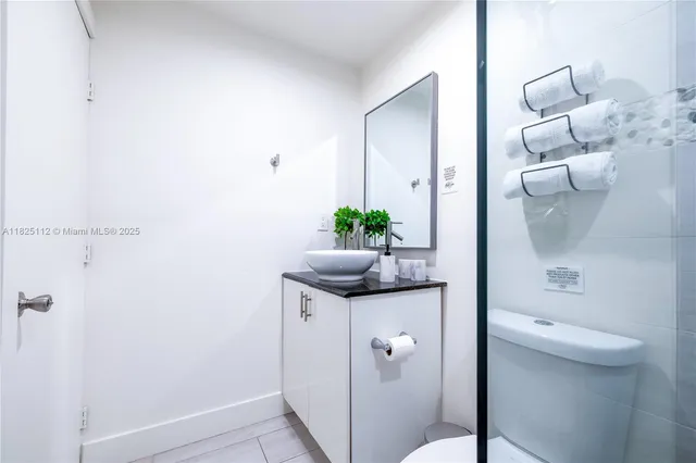 a bathroom with a granite countertop sink a toilet and shower
