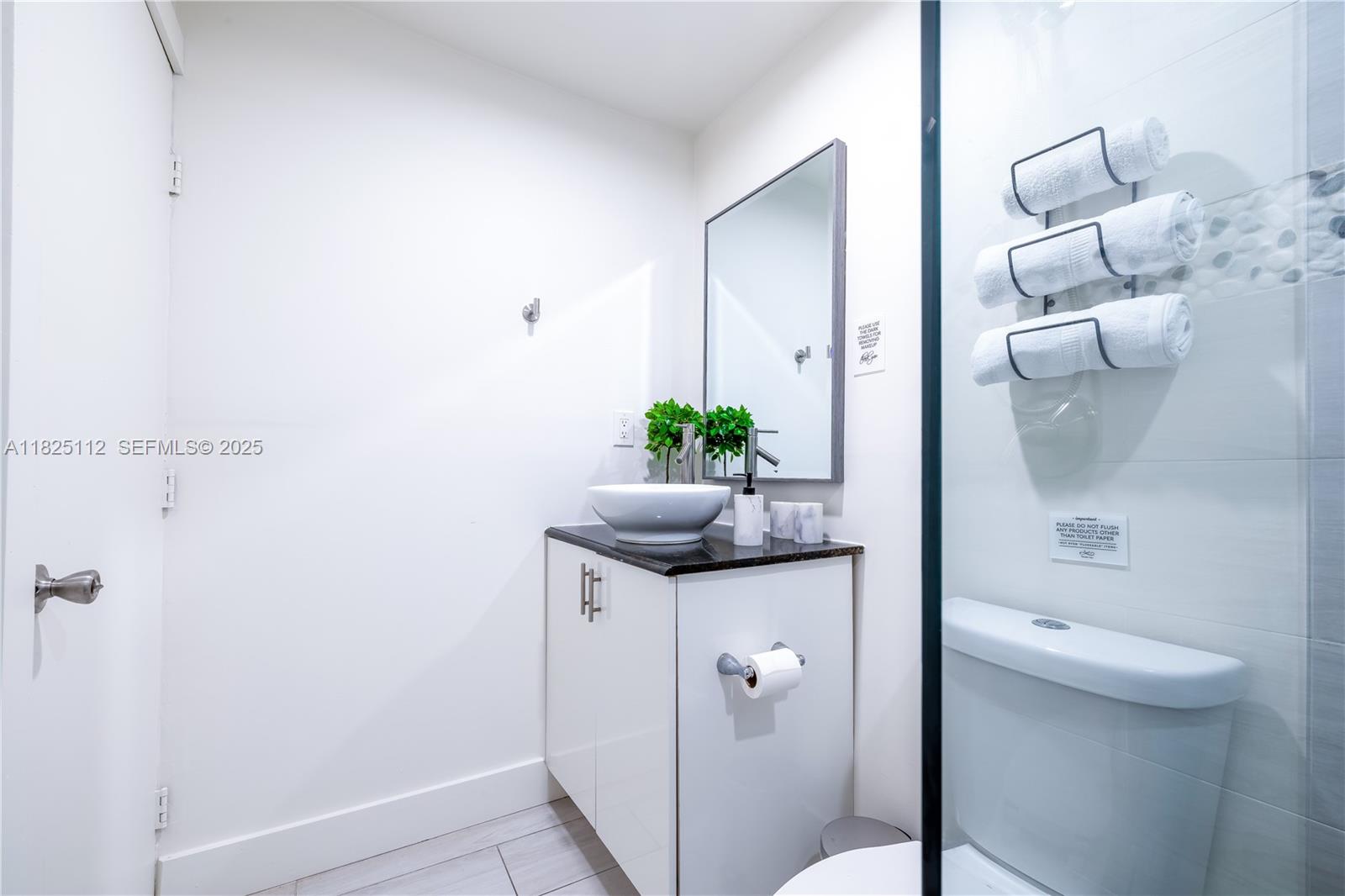 1836 Northwest 16th Terrace, Unit 3 Miami, FL 33125 - Photo 9 of 15 a bathroom with a granite countertop sink a toilet and shower