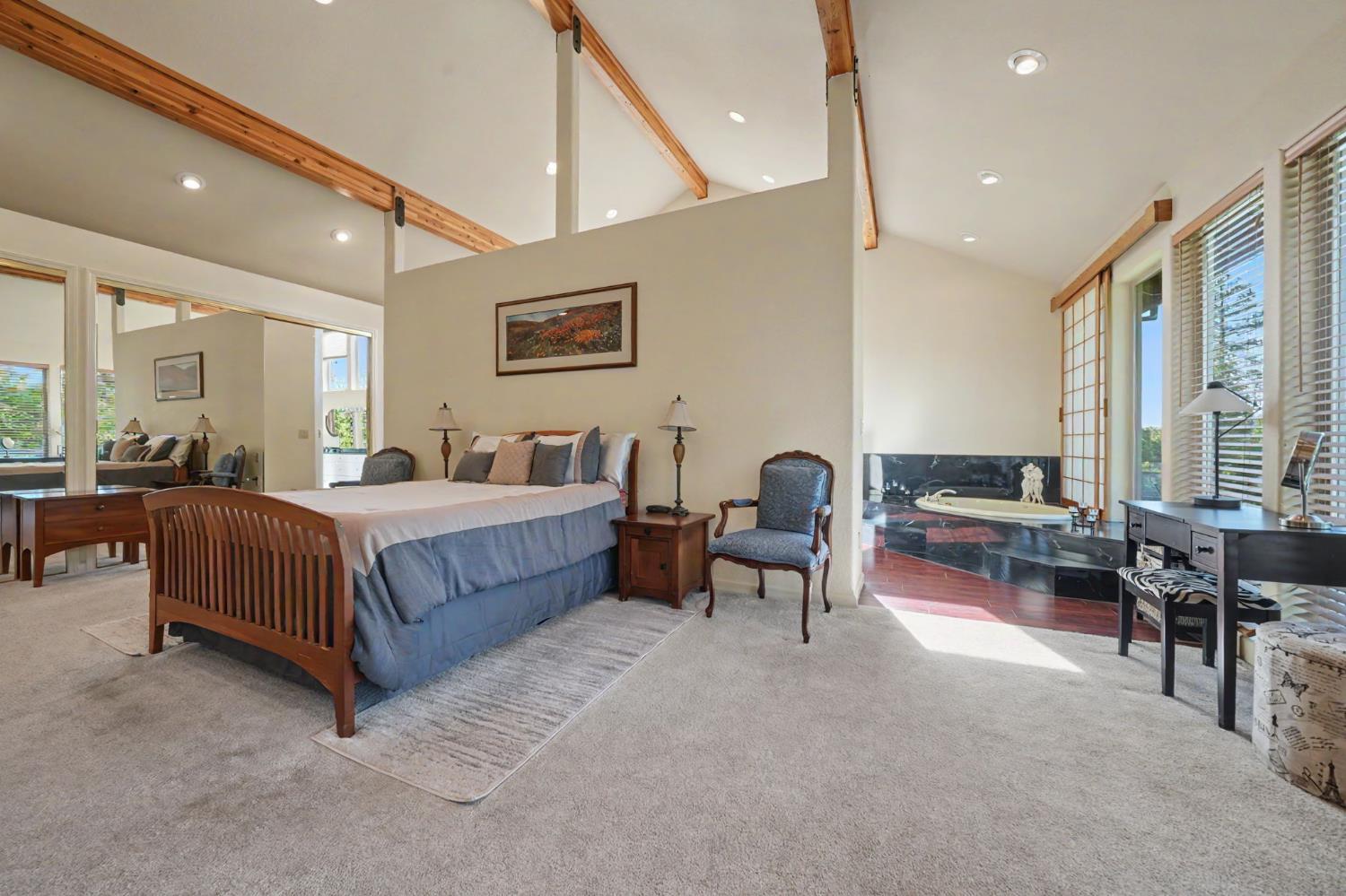 12091 Mierkey Road Jackson, CA 95642 - Photo 22 of 87 a spacious bedroom with a bed and a table
