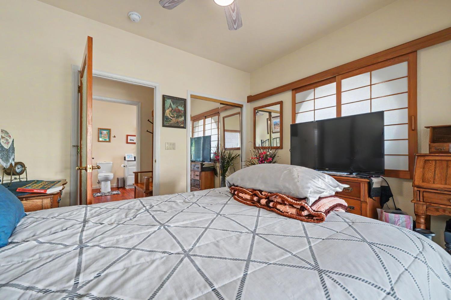 12091 Mierkey Road Jackson, CA 95642 - Photo 62 of 87 a bedroom with a large bed and a flat tv screen on dresser