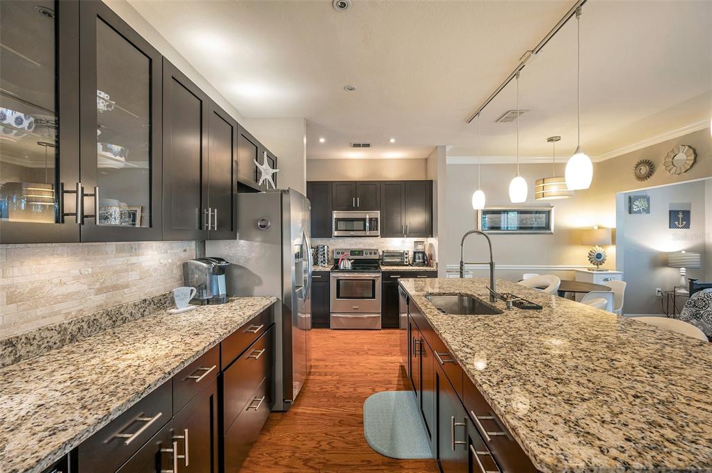 2245 Chianti Place, Unit 724 Palm Harbor, FL 34683 - Photo 16 of 76 a large kitchen with kitchen island a large counter appliances and a sink