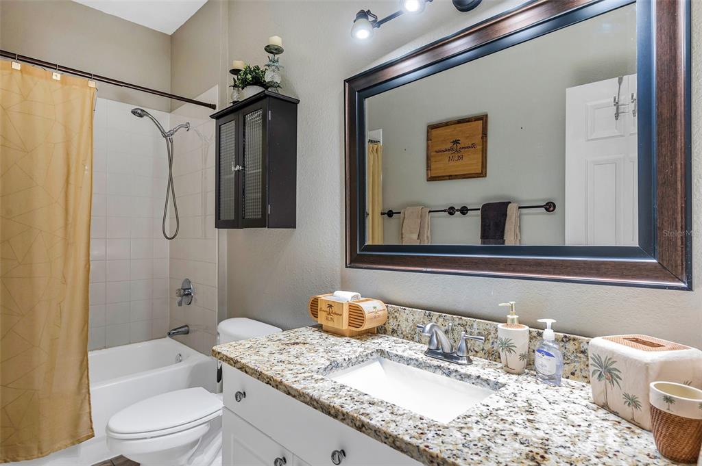 2245 Chianti Place, Unit 724 Palm Harbor, FL 34683 - Photo 26 of 76 a bathroom with a granite countertop sink toilet and shower
