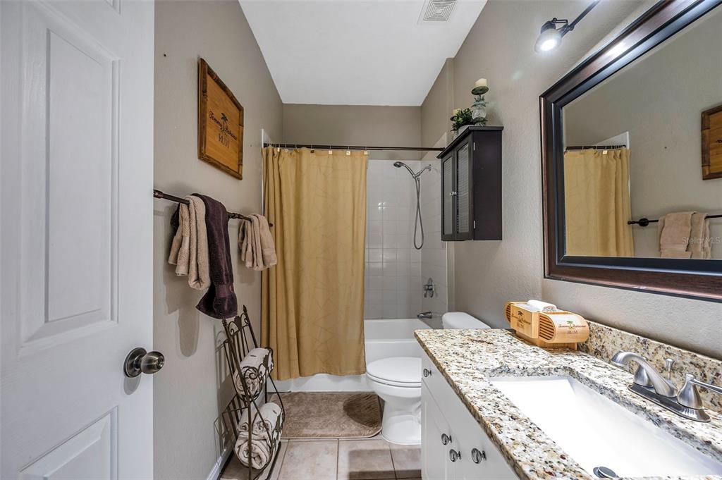 2245 Chianti Place, Unit 724 Palm Harbor, FL 34683 - Photo 27 of 76 a bathroom with a granite countertop sink a mirror and shower