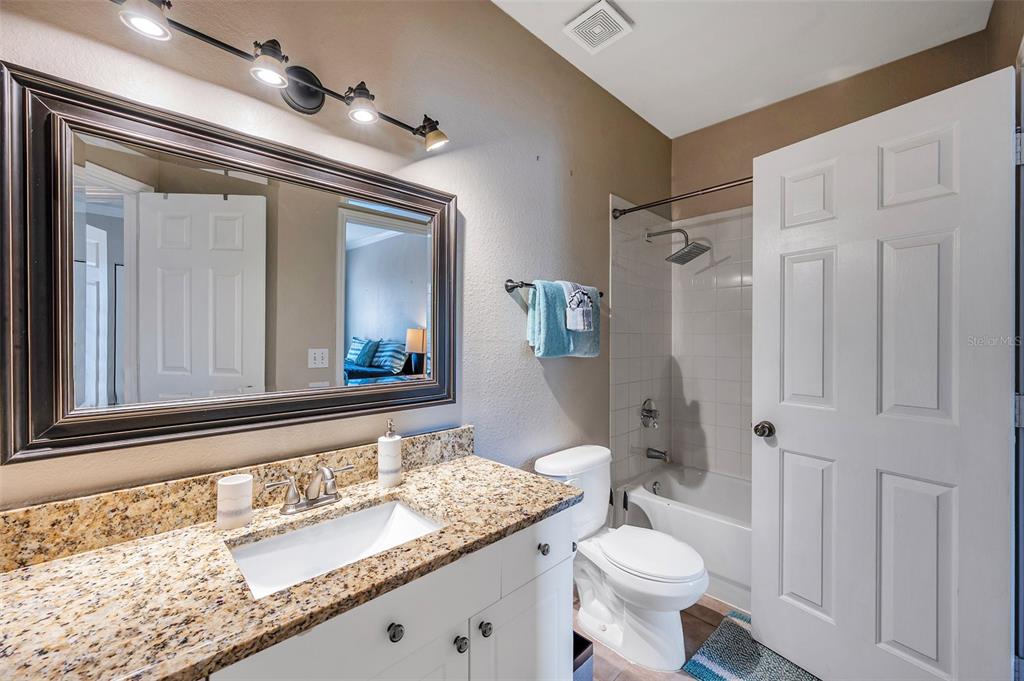 2245 Chianti Place, Unit 724 Palm Harbor, FL 34683 - Photo 32 of 76 a bathroom with a granite countertop sink toilet and shower