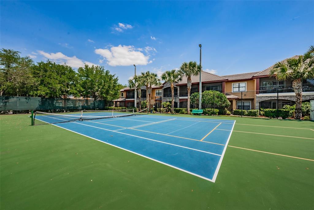 2245 Chianti Place, Unit 724 Palm Harbor, FL 34683 - Photo 73 of 76 a view of a tennis ground with large trees