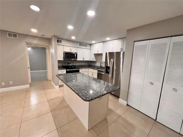 a kitchen with stainless steel appliances granite countertop a refrigerator and a sink