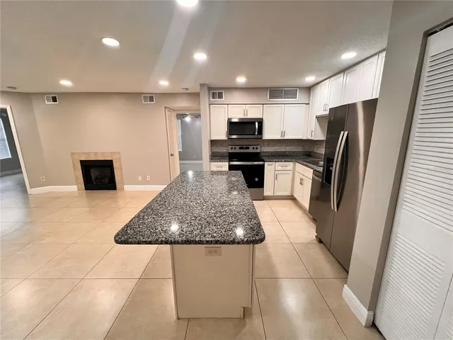 a kitchen with stainless steel appliances granite countertop a refrigerator and a stove