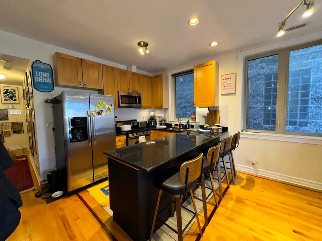 a kitchen with stainless steel appliances granite countertop a sink a stove and a refrigerator