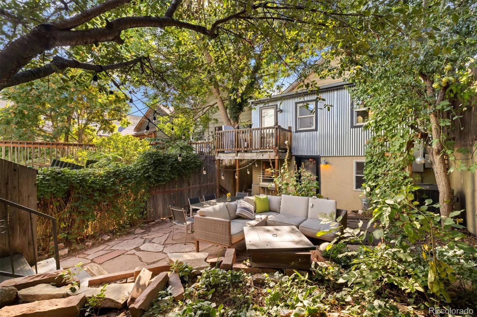 a view of a patio with couches table and chairs under an umbrella