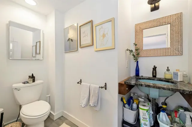 a bathroom with a toilet sink and mirror