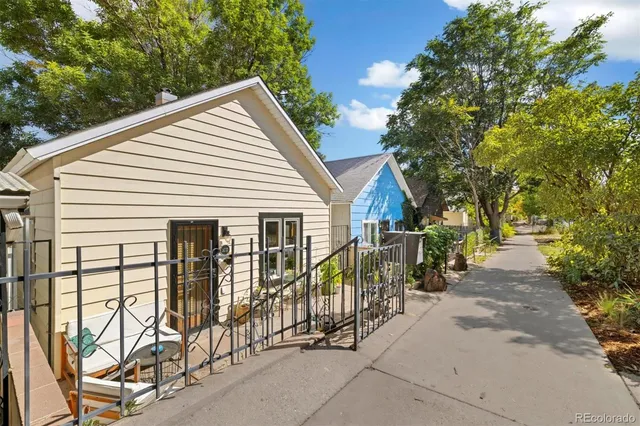 a view of a house with large trees and plants
