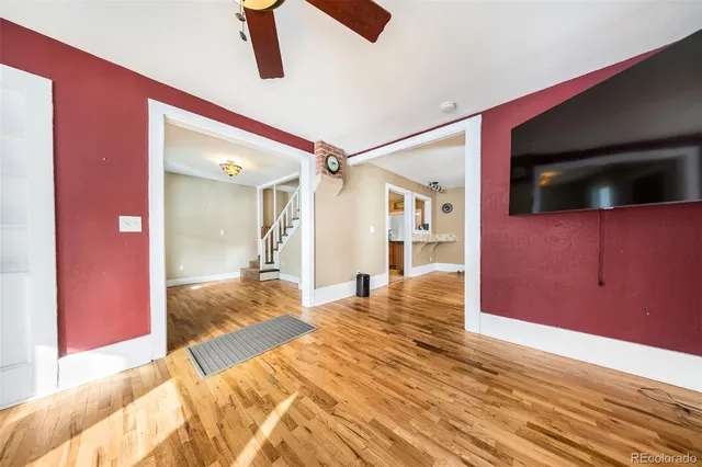 a view of a livingroom with wooden floor and bedroom