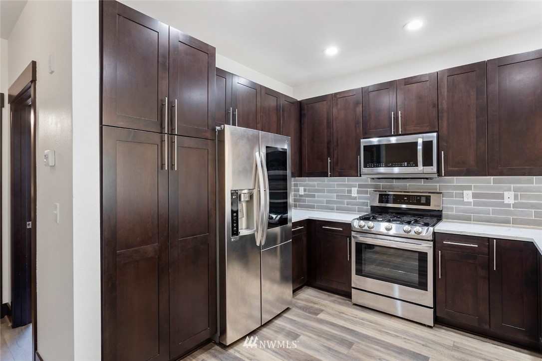 4004 Northeast 3rd Place Renton, WA 98056 - Photo 2 of 25 a kitchen with stainless steel appliances granite countertop a refrigerator and a stove top oven