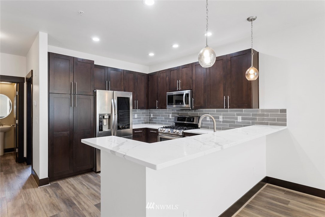4004 Northeast 3rd Place Renton, WA 98056 - Photo 4 of 25 a kitchen with stainless steel appliances a refrigerator sink and microwave