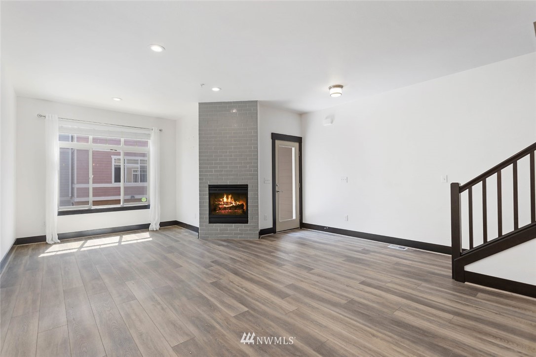 4004 Northeast 3rd Place Renton, WA 98056 - Photo 8 of 25 an empty room with wooden floor fireplace and windows