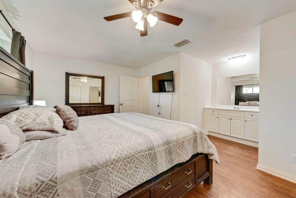 905 Pepperidge Court Lancaster, TX 75134 - Photo 11 of 19 a bedroom with a bed a mirror on dresser and a chandelier