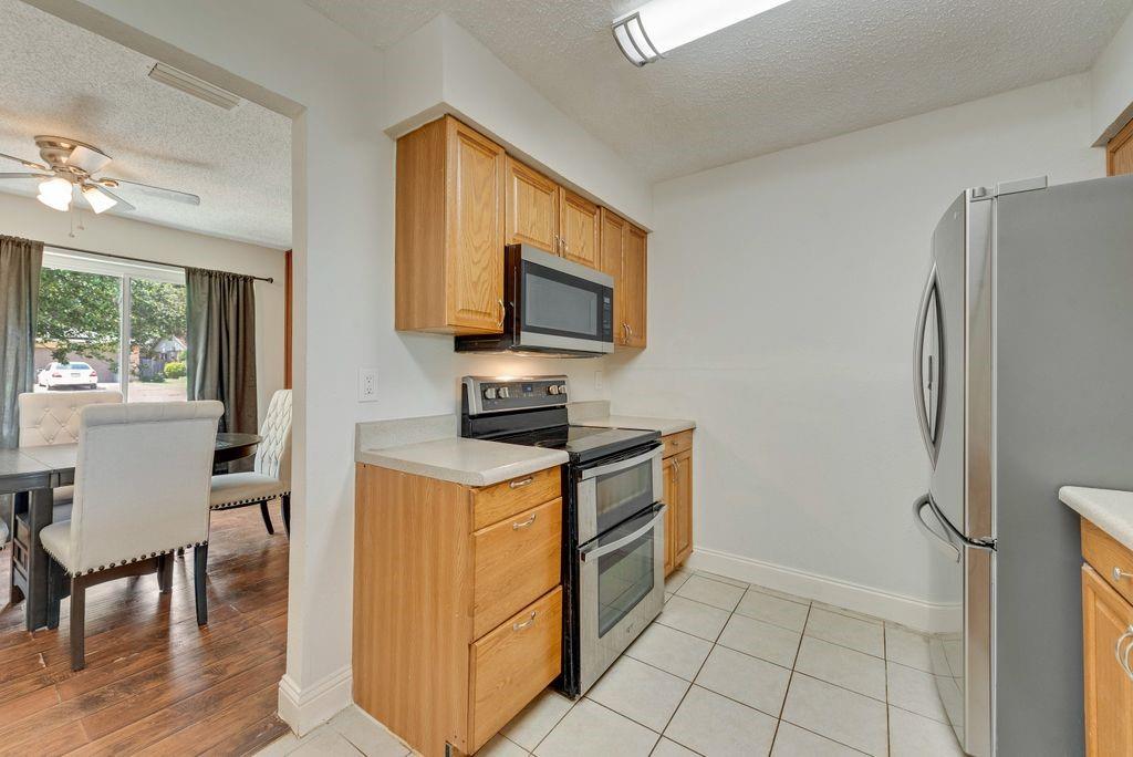 905 Pepperidge Court Lancaster, TX 75134 - Photo 4 of 19 a kitchen with stainless steel appliances granite countertop a stove top oven a sink dishwasher a dining table and chairs with wooden floor