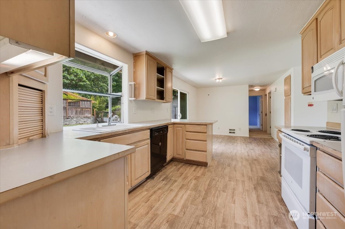 107 231st Street Southeast Bothell, WA 98021 - Photo 12 of 39 a kitchen with stainless steel appliances a stove top oven a sink a counter space and cabinets