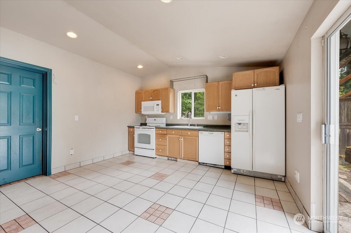 107 231st Street Southeast Bothell, WA 98021 - Photo 32 of 39 a kitchen with a refrigerator a stove top oven and cabinets