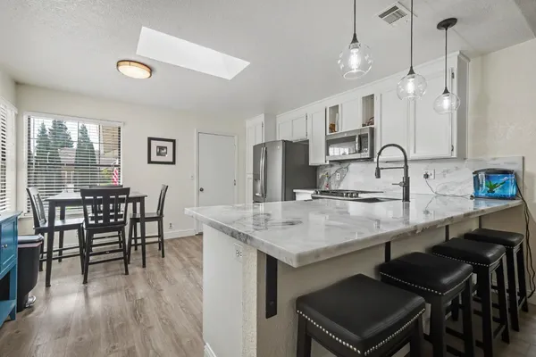 a kitchen with kitchen island white cabinets and stainless steel appliances