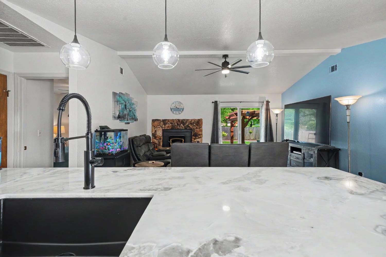 67 St Andrews Road Valley Springs, CA 95252 - Photo 23 of 58 a living room with fireplace furniture and a chandelier