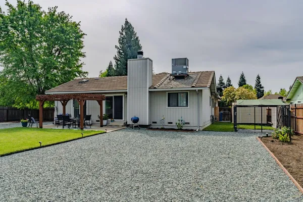 a view of a house with backyard and sitting area