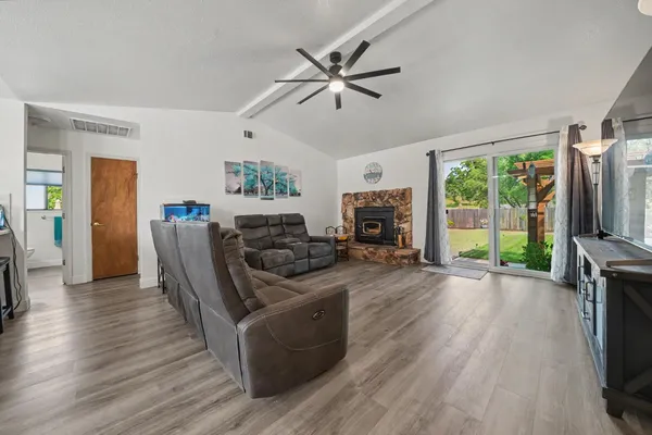 a living room with furniture a flat screen tv and a fireplace