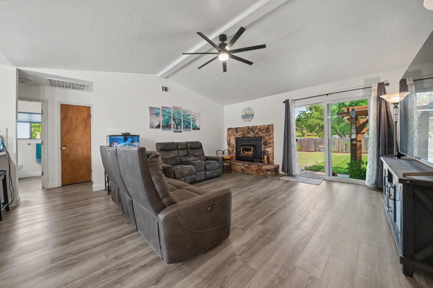 67 St Andrews Road Valley Springs, CA 95252 - Photo 8 of 58 a living room with furniture a flat screen tv and a fireplace