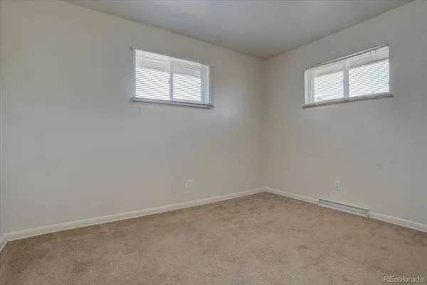 an empty room with windows and closet