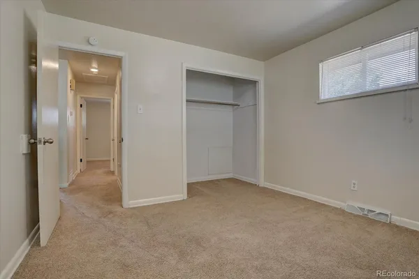 an empty room with windows and closet