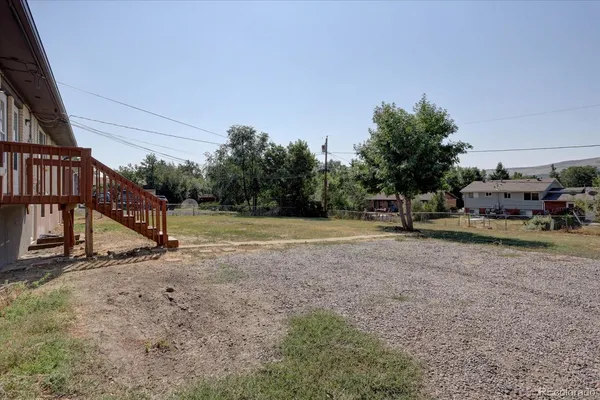 a backyard of a house with table and chairs