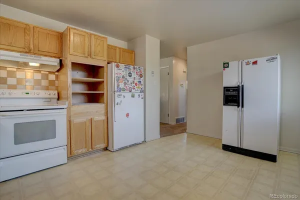 a kitchen with a refrigerator and a sink